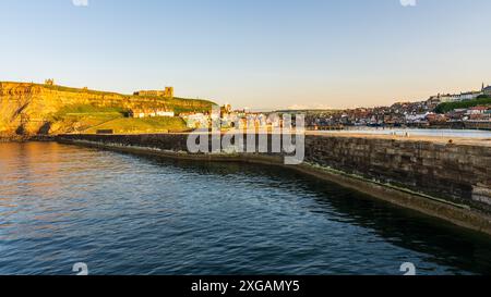 Whitby, North Yorkshire, Angleterre, Royaume-Uni - 21 juin 2023 : Golden Hour over the Houses on the East Cliff and the Church of St Mary Banque D'Images