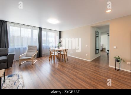 Intérieur de la salle de séjour moderne. Luxueux appartement moderne et élégant. Espace ouvert, canapé élégant, table basse, design scandinave. Fenêtres et rideau Banque D'Images