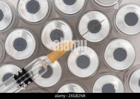 Impfung mit Ampullen und Spritze Eine Impfspritze liegt auf Ampullen mit sérum für eine Impfung *** vaccination avec ampoules et seringue A vaccinatio Banque D'Images