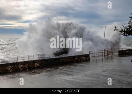 Mer agitée avec de grosses vagues sur les quais du front de mer de Gênes, Italie Banque D'Images