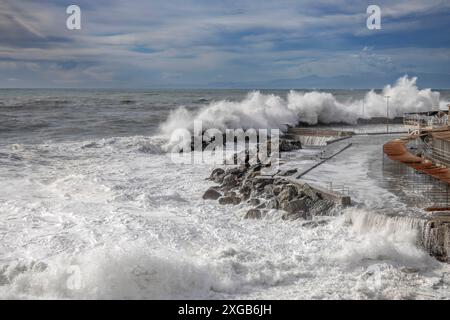 Mer agitée avec de grosses vagues sur les quais du front de mer de Gênes, Italie Banque D'Images