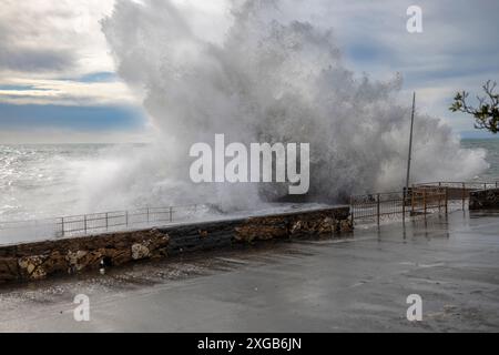 Mer agitée avec de grosses vagues sur les quais du front de mer de Gênes, Italie Banque D'Images