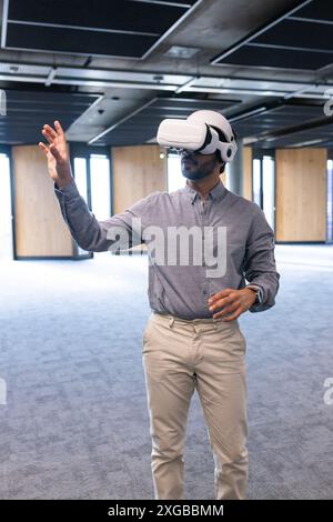 En utilisant le casque VR, l'homme interagissant avec l'environnement virtuel dans le bureau moderne Banque D'Images