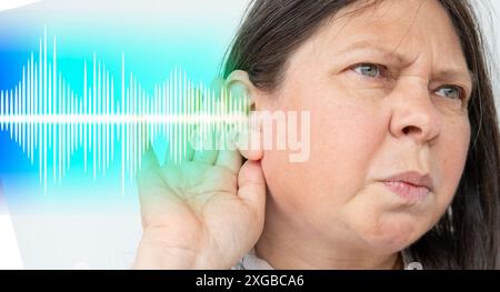 Femme mature caucasienne tenant l'oreille gros plan écoute, onde sonore, acoustique système auditif, test auditif, implant cochléaire, dévic. d'assistance auditive Banque D'Images