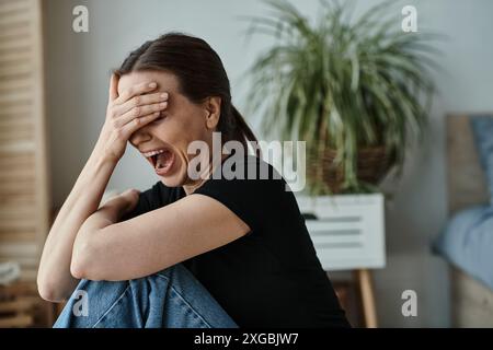 Femme d'âge moyen, éprouvant une dépression mentale, couvre le visage avec les mains en détresse. Banque D'Images