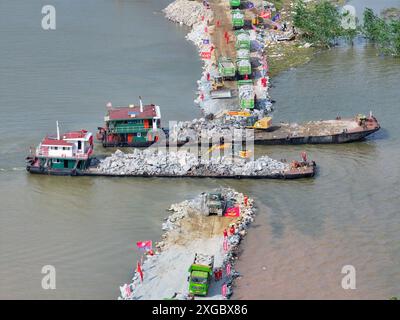 Huarong, province chinoise du Hunan. 8 juillet 2024. Une photo de drone aérien montre des sauveteurs travaillant pour bloquer la brèche de digue dans le lac Dongting dans le comté de Huarong, dans la province du Hunan, au centre de la Chine, le 8 juillet 2024. Lundi après-midi, 180,5 mètres de la brèche de 226 mètres dans la digue avaient été scellés, selon le siège de lutte contre les inondations et de secours contre la sécheresse de Yueyang. Crédit : Chen Zeguo/Xinhua/Alamy Live News Banque D'Images