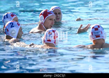 Marko Bijac, de Croatie, discute avec ses coéquipiers avant le match de water-polo masculin de la Coupe Sardinia entre la Croatie (casquettes blanches) et l’Espagne (casquettes bleues) au piscina comunale à Alghero (Italie), le 6 juillet 2024. L'Espagne a gagné 12-11 sur la Croatie. Banque D'Images