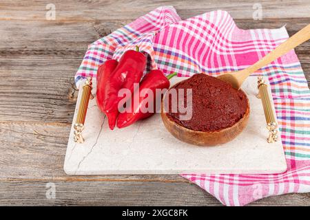 Pâte de piment fort traditionnelle. Cuisine turque. Cuisine turque pâte de poivre épice dans un bol de pâte de poivron rouge chaud sur la table en bois gros plan. Banque D'Images