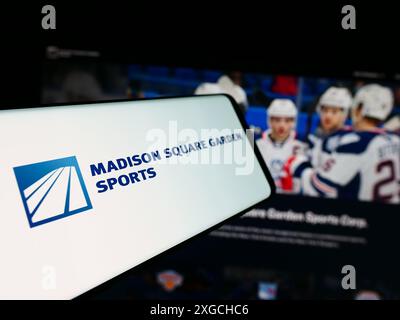 Smartphone avec le logo de la société américaine Madison Square Garden Sports Corp. en face du site Web de l'entreprise. Mettez l'accent sur le centre-gauche de l'écran du téléphone. Banque D'Images