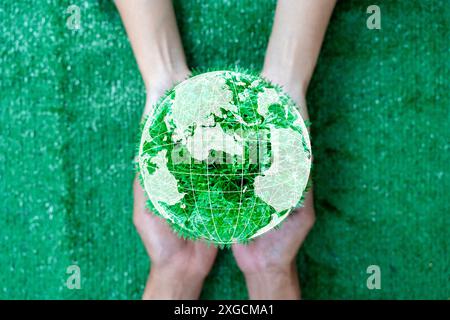 Concept de Journée mondiale de la Terre. Energie verte, ESG, ressources renouvelables et durables. Respect de l'environnement. Mains de gens embrassant un Globe fait main. Prote Banque D'Images