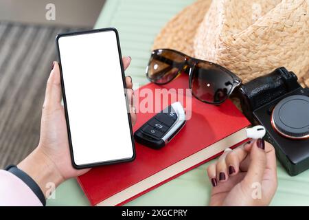 Gros plan d'une femme portant des écouteurs vérifiant l'écran vide sur un téléphone portable couché sur un canapé à la maison. Main féminine tenant un smartphone vierge, social me Banque D'Images