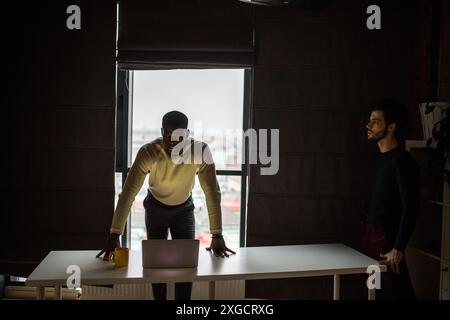 Teint foncé sérieux d'affaires, se sentir inquiets de nouveau projet d'entreprise, vêtu de blanc, pull tricoté passe temps libres à l'office de tourisme, à la une Banque D'Images