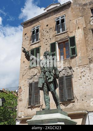 Statue du général Jean-Pierre Gaffory devant un bâtiment avec de nombreux trous de balles à Corte, Corse, France Banque D'Images