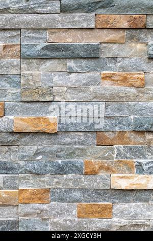 Un mur de pierre multicolore, mettant en valeur la texture et le détail du travail de maçonnerie. Banque D'Images