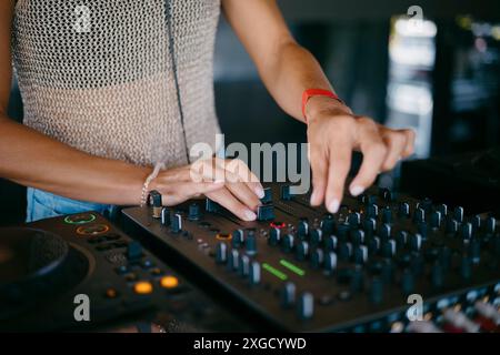 Femme DJ mains créer et réguler la musique sur console dj mixeur dans un festival de musique Banque D'Images