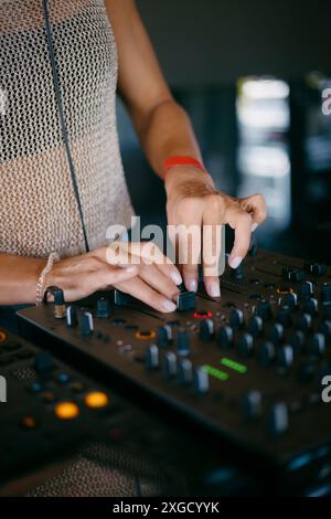 Femme DJ mains créer et réguler la musique sur console dj mixeur dans un festival de musique Banque D'Images