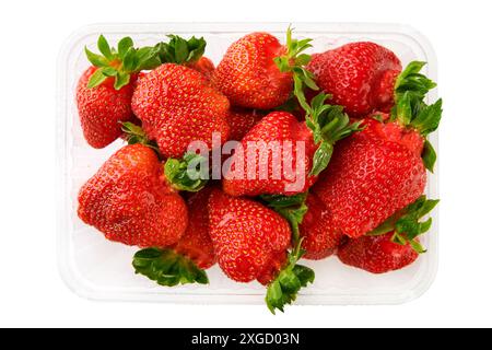 Fraises rouges laides avec des tiges vertes et des gouttes d'eau dans un récipient en plastique isolé sur fond blanc. Récipient de boîte en plastique de supermarché avec frais Banque D'Images