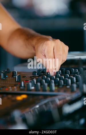 Vue rapprochée d'un DJ mains créant et régulant la musique sur console dj mixeur dans un festival de musique Banque D'Images