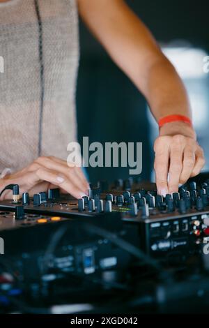 Femme DJ mains créer et réguler la musique sur console dj mixeur dans un festival de musique Banque D'Images