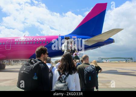 Aéroport de Gatwick - passagers embarquant sur un vol aérien Whizz via des escaliers mobiles avec bagages, sacs à dos, etc Banque D'Images