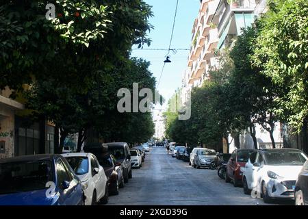 athènes grèce eu- une rue bordée d'arbres pleine de voitures garées Banque D'Images