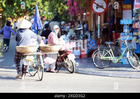 Hoi an, Vietnam 7 juillet 2024 : hawker déplace la stalle et être prêt pour le marché de nuit. La vieille ville est un port de commerce d'Asie du Sud-est datant du 15ème Banque D'Images