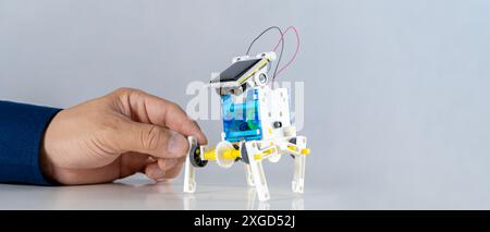 Homme inventant des robots de construction apprenant des voitures ensemble dans la classe STEM. Étudiants heureux, enfants apprenant ensemble à construire des robots en classe à la science Banque D'Images