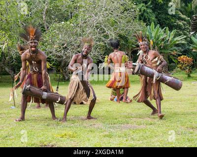 Six groupes différents de guerriers indigènes, batteurs et danseurs se produisent sur l'île de Kwato, en Papouasie-Nouvelle-Guinée, dans le Pacifique Banque D'Images