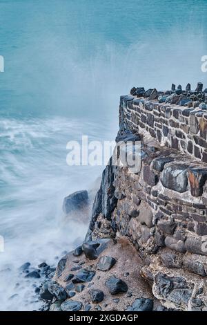 Rivage du soir, surf de l'Atlantique s'écrasant contre le mur du port à Hartland Quay, nord du Devon, Angleterre, Royaume-Uni, Europe Banque D'Images