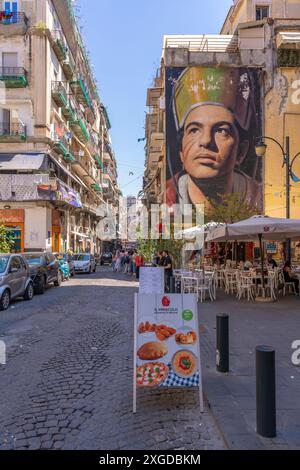 Vue sur les cafés et San Gennaro di Jorit Agoch sur l'animation via Forcella, Naples, Campanie, Italie, Europe Banque D'Images