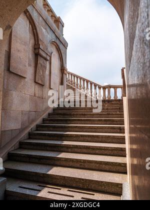 Escalier en pierre avec balustrades ornées menant au balcon, face au ciel dégagé, architecture classique. Banque D'Images