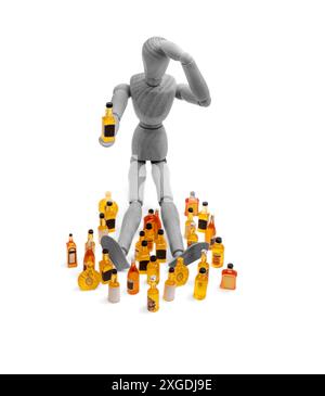 l'homme avec la boisson, un mannequin en bois couché tient des bouteilles de boisson à côté d'une pile de bouteilles de boisson miniatures Banque D'Images