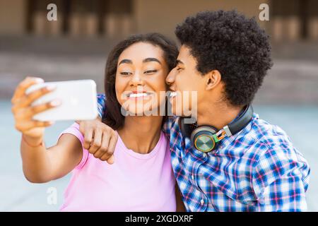 Un couple afro-américain souriant emmène Selfie à l'extérieur Banque D'Images