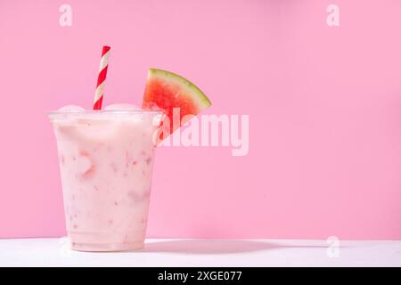 Délicieux milkshake sucré à la pastèque ou cocktail de slushie crémeux, garni de tranche de pastèque dans une tasse en plastique, espace de copie Banque D'Images