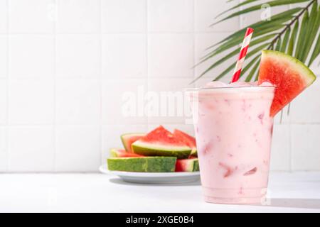 Délicieux milkshake sucré à la pastèque ou cocktail de slushie crémeux, garni de tranche de pastèque dans une tasse en plastique, espace de copie Banque D'Images