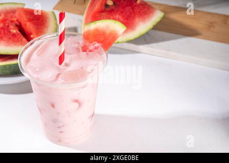 Délicieux milkshake sucré à la pastèque ou cocktail de slushie crémeux, garni de tranche de pastèque dans une tasse en plastique, espace de copie Banque D'Images
