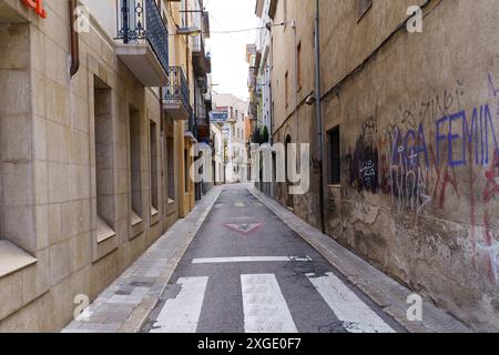 Figueres, Espagne - 14 mai 2023 : une rue vide à Figueres, Espagne, avec un mur de briques recouvert de graffitis. Banque D'Images