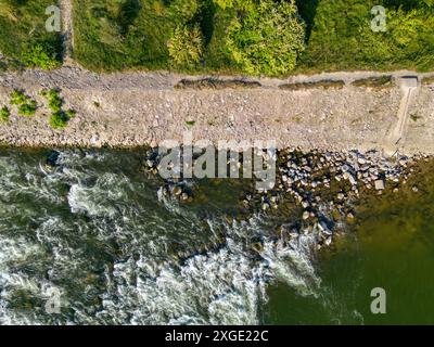 Vue aérienne de haut en bas du remblai de la rivière Sava à côté des rapides de la rivière éclaboussant des rochers submergés Banque D'Images