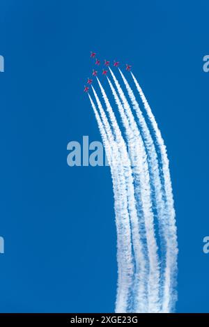 L'équipe d'affichage des flèches rouges de la RAF lors du Sywell Airshow 2024 dans le Northamptonshire, au Royaume-Uni, s'élevant haut dans un ciel bleu traînant de la fumée blanche Banque D'Images