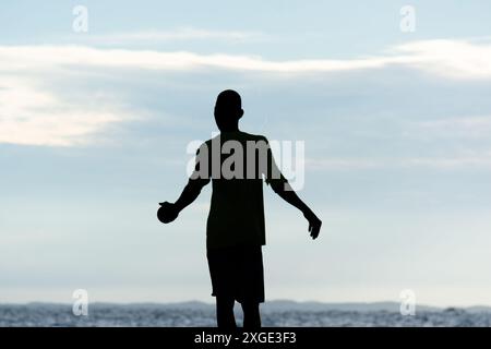 Salvador, Bahia, Brésil - 17 mai 2019 : un pêcheur non identifié, en silhouette, est vu jetant une ligne de nylon avec un appât dans l'eau de Rio Vermelho Banque D'Images