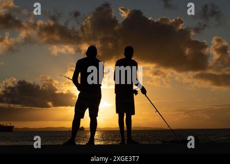 Salvador, Bahia, Brésil - 14 septembre 2019 : des pêcheurs non identifiés, en silhouette, observent les poissons dans les eaux de la plage de Ponta do Humaita Banque D'Images