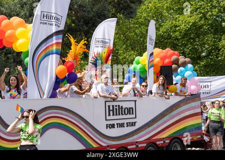 Les gens dans un bus sponsorisé par Hilton célébrant la Pride 2024 sur Park Lane, Londres, le 29 juin 2024. Concept : fier, diversité, inclusion Banque D'Images