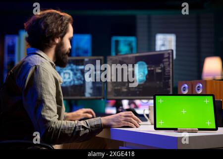 Concentrez-vous sur la tablette maquette avec IA sensible en arrière-plan flou gagnant en forme humanoïde, parlant avec l'homme. Écran vert à côté de l'intelligence artificielle auto-consciente sur PC discutant avec un ingénieur INFORMATIQUE Banque D'Images