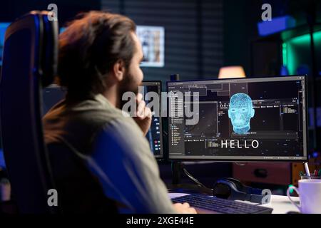 Professionnel DE L'INFORMATIQUE agréablement surpris après avoir réussi à avoir une conversation avec l'intelligence artificielle sur ordinateur. Programmeur souriant regardant l'écran du PC après avoir atteint l'objectif de parler avec l'IA Banque D'Images