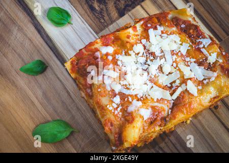 Titel : vue de dessus d'une lasagne maison, sur un bois à coudre, décoré de basilic. Banque D'Images