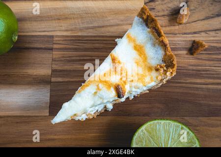 Une tarte au citron faite maison, sur une assiette en bois. Décoré de citrons. Banque D'Images