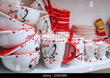 Strasbourg, France - 2 juin 2023 : mugs en céramique aux motifs alsaciens traditionnels avec des cigognes exposées dans une boutique de souvenirs Banque D'Images