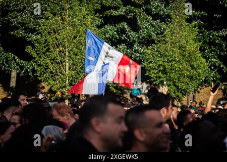 Un drapeau français avec les lettres LFI (la France insoumise) vu au milieu de la foule suite aux résultats des élections législatives françaises. Après avoir perdu le premier tour des élections législatives françaises, la coalition de gauche Nouveau Front populaire remporte le second tour. Des milliers de personnes sont descendues dans les rues et ont célébré la place Stalingrad, devant le siège de la France Insoumise, avec des discours de plusieurs personnalités du parti. Un autre point fort des célébrations a été, inévitablement, la place de République, avec plusieurs enregistrements d'affrontements entre la police et les manifestants. Banque D'Images