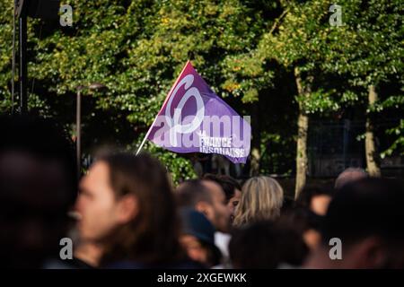 Un drapeau du parti la France insoumise vu au milieu de la foule sur la place de Stalingrad, suite aux résultats des élections législatives françaises. Après avoir perdu le premier tour des élections législatives françaises, la coalition de gauche Nouveau Front populaire remporte le second tour. Des milliers de personnes sont descendues dans les rues et ont célébré la place Stalingrad, devant le siège de la France Insoumise, avec des discours de plusieurs personnalités du parti. Un autre point fort des célébrations a été, inévitablement, la place de République, avec plusieurs enregistrements d'affrontements entre la police et les manifestants. Banque D'Images