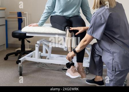 Ajustement de la jambe prothétique, professionnel de santé assistant le patient en clinique Banque D'Images